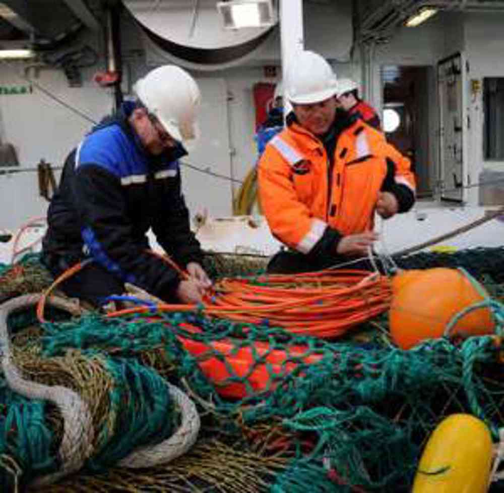 Jan Tore Øvredal og Asbjørn Aasen (til høyre) i gang med å montere observasjonsutstyr i trålen. Foto: Kjartan Mæstad/IMR.